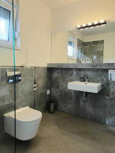a bathroom with a toilet and a sink at More i Sol Rab Pool House in Rab