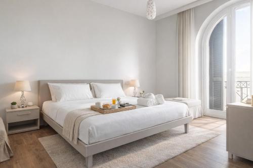 ein weißes Schlafzimmer mit einem großen Bett und einem Tablett darauf in der Unterkunft Vatican Pertusa Luxury Suites by Quinto Piano in Rom