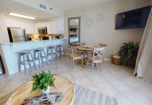 una cucina e un soggiorno con tavolo e sedie di Beach Club 1109 D a Gulf Shores