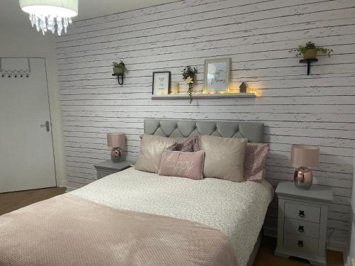 een slaapkamer met een bed met roze en witte kussens bij Double room with en-suite in Halton