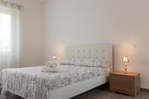 een slaapkamer met een wit bed met een teddybeer erop bij ArtStay Apt Humanitas, Two Rooms, Parking in Rozzano