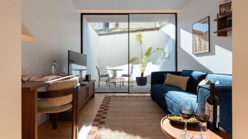 a living room with a blue couch and a table at Ando Living - São Miguel House in Porto