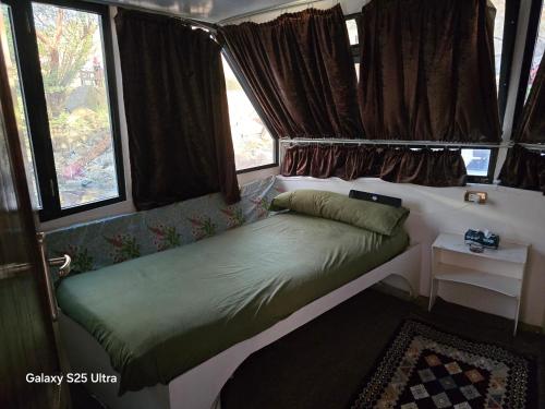 un piccolo letto in una camera con finestre di The Grand a Aswan