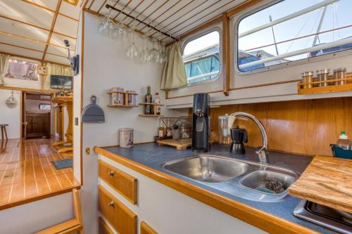 a kitchen in an rv with a sink at Bateau Gré - Sur le quai in Saint-Gilles