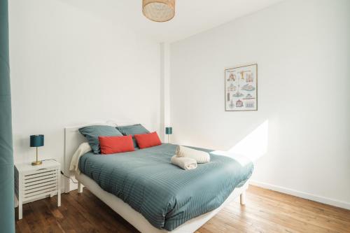 una camera da letto con un letto con cuscini rossi e blu di Nid douillet en duplex proche Centre-ville & Tram a Nantes