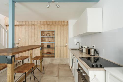 una cucina con mobili bianchi, tavolo e sedie di Nid douillet en duplex proche Centre-ville & Tram a Nantes