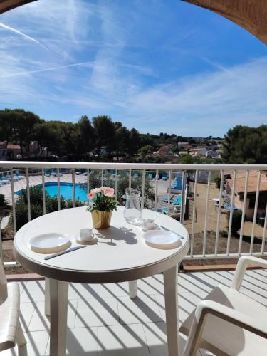 een witte tafel op een balkon met uitzicht op de oceaan bij Les Hauts de Balaruc in Balaruc-les-Bains