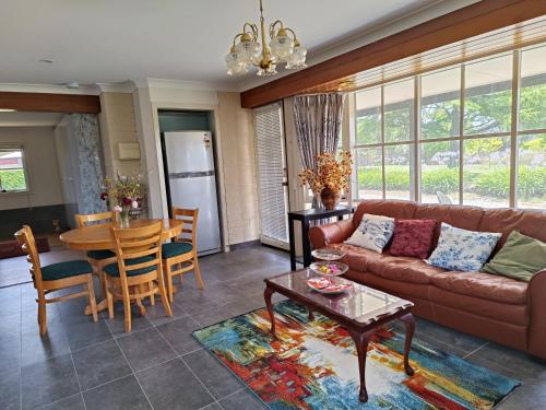 a living room with a couch and a table at Grandvista Cottage in Yering