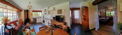 a living room with a table and a couch at Grandvista Cottage in Yering