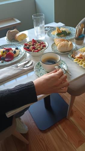 una persona seduta a un tavolo con piatti di cibo di Casa Zogbi Hotel a Porto
