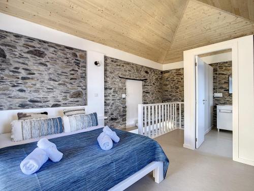 ein Schlafzimmer mit einem großen Bett mit zwei Kissen in der Unterkunft Villa Espigão With Pool in Fajã da Ovelha