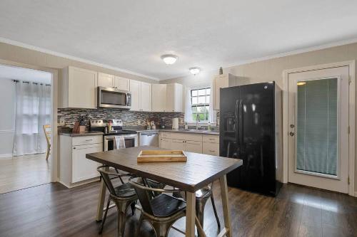 费耶特维尔Home Base的厨房配有桌子和黑冰箱。