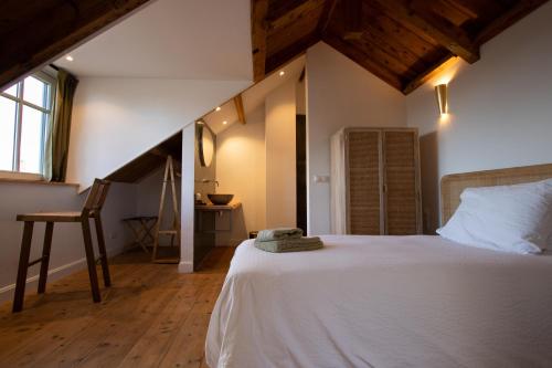 a bedroom with a white bed and a chair at Fika in Renesse