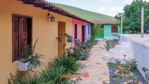 ein Haus mit einem Garten, vor dem ein Kuchen steht in der Unterkunft Suite Quadrupla em Rio Grande Com Piscina in Conceição do Gato