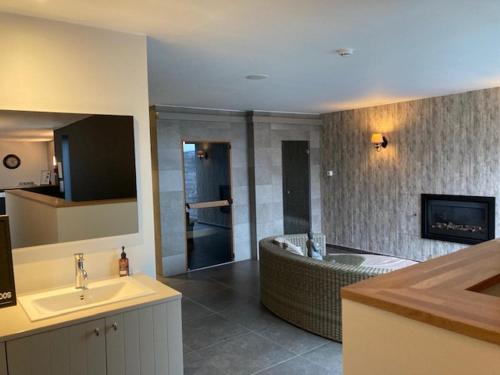 een badkamer met een bad en een wastafel en een badkamer bij La vie en Roos in Maldegem