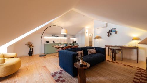 a living room with a blue couch and a kitchen at Ando Living - São Miguel House in Porto