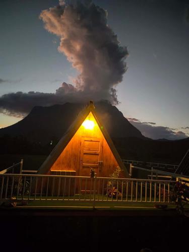 a lit up cabin with a mountain in the background at Western View Chiangdao Camping in Chiang Dao
