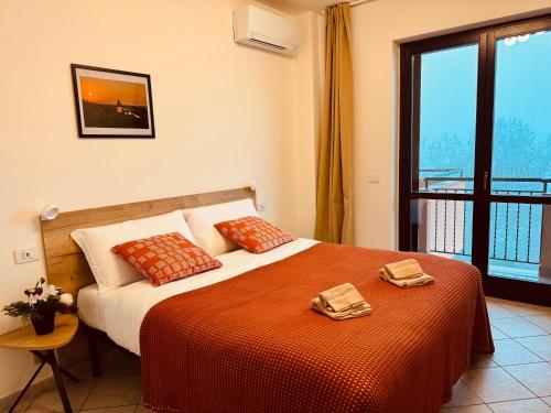 ein Schlafzimmer mit einem Bett und einem großen Fenster in der Unterkunft Casa di Stella in Montepulciano