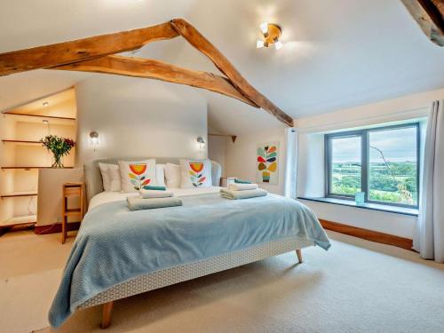 een slaapkamer met een groot bed met een groot raam bij 2 Bed in Bude oc-64088 in Marhamchurch