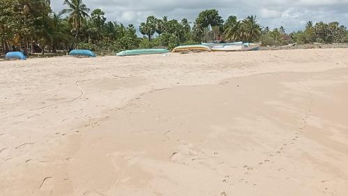 une plage de sable avec trois bateaux dessus dans l'établissement Shalom Beach Villa, à Kalkudah