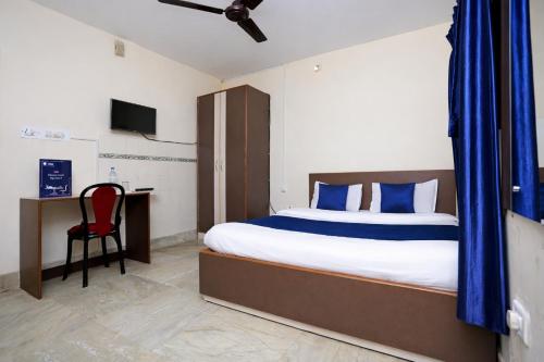 a bedroom with a bed and a desk with a red chair at Hotel #Blue Moon# Front Of Bhubaneswar Railway Station in Bhubaneshwar