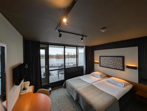 ein Hotelzimmer mit einem Bett und einem großen Fenster in der Unterkunft Hotel Princenhof in Earnewâld