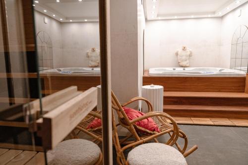 a room with two wicker chairs and a mirror at Suite Jacuzzi & Sauna privatifs - Paris - Or Norme By Le Douze in Paris