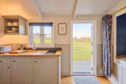een keuken met een wastafel en een deur naar een tuin bij Host and Stay - Florence in Marsham