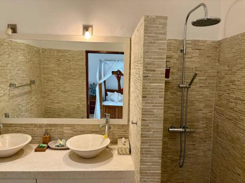 een badkamer met twee wastafels en een douche bij Beachfront Villa Nirwana with Private Jacuzzi in Pengastulan