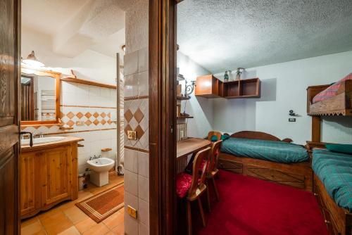ein Schlafzimmer mit Bett und ein Badezimmer mit Waschbecken in der Unterkunft tHE Courmaison - Courmayeur in Courmayeur