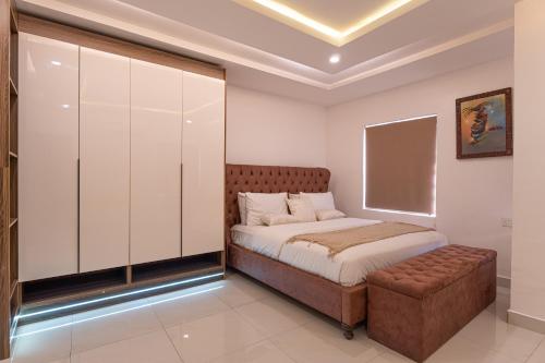 a bedroom with a bed and a bench in it at Virginia Apartments in Addo