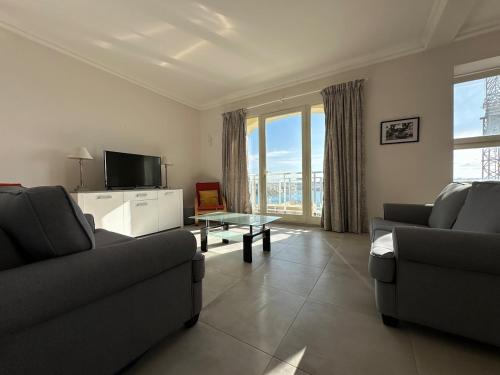 a living room with two couches and a tv at Valletta Minimal, Breezy, Coastal chic City Life in Valletta