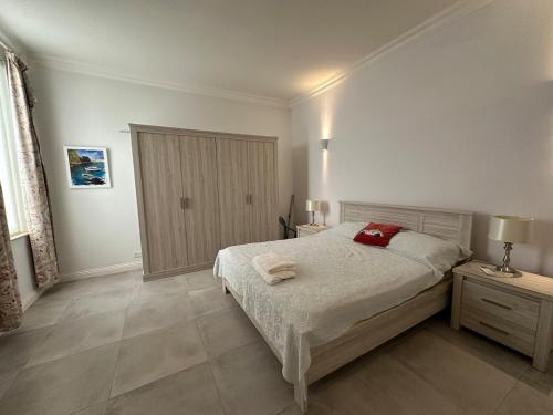 a white bedroom with a bed and two night stands at Valletta Minimal, Breezy, Coastal chic City Life in Valletta