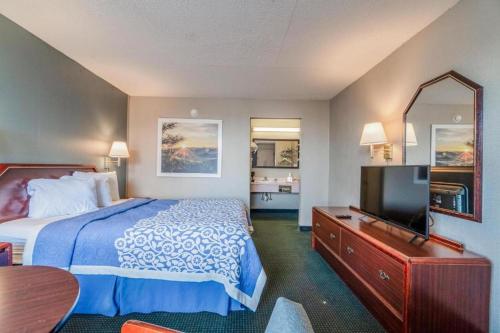 a hotel room with a bed and a flat screen tv at Ozark Junction Inn in Mountain View