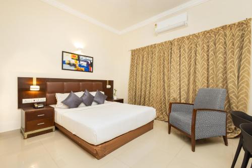 a bedroom with a bed and a desk and a chair at The Senate Hotel By Addon Group in Cochin