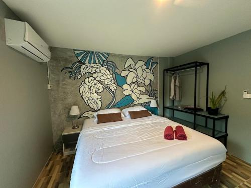 een slaapkamer met een bed met rode schoenen erop bij Sea view house, swimming pool in Ko Chang