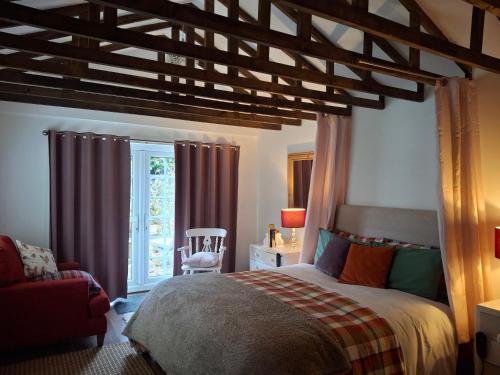 a bedroom with a bed and a chair and a window at The LITTLE HOUSE in HULL in Hull