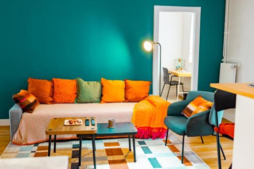 een woonkamer met een bank met kleurrijke kussens bij La Petite Perle de Noisy in Noisy-le-Grand