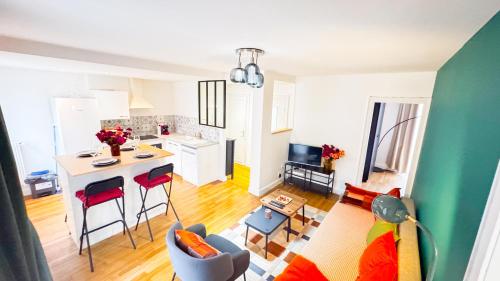 een keuken en woonkamer met een tafel en stoelen bij La Petite Perle de Noisy in Noisy-le-Grand