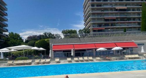 una piscina accanto a un edificio con tetto rosso di NICE BAIE DES ANGES a Nizza