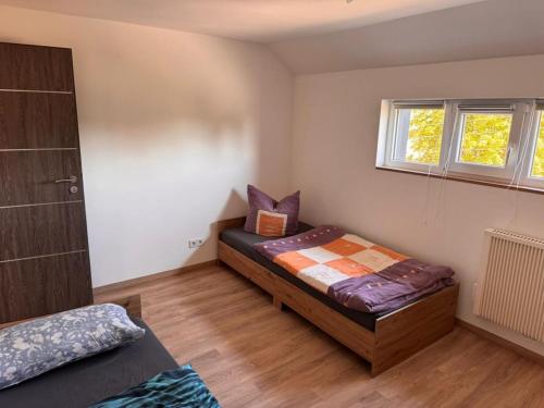 una piccola camera da letto con un letto e una finestra di NEU! Ferienwohnung Elsteraue DG oben a Meuselwitz