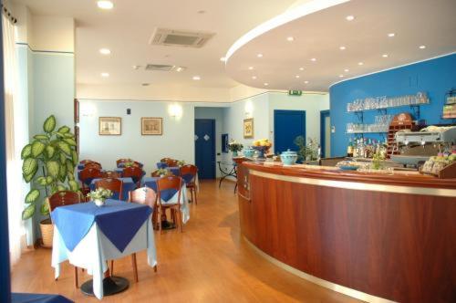 ein Restaurant mit einer Bar, einem Tisch und Stühlen in der Unterkunft Hotel La Vela in Passignano sul Trasimeno