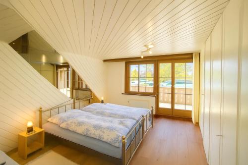 a bedroom with a bed and a large window at Tannenheim Lodge Flumserberg in Flumserberg