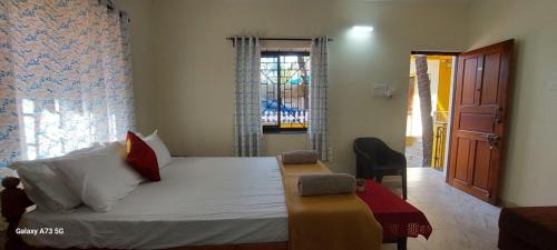 een slaapkamer met een groot bed en een raam bij Bal Ganesha beach resort in Canacona