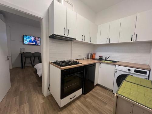 eine Küche mit weißen Schränken und einem Herd mit Backofen in der Unterkunft Unirii Square Studio in Iaşi