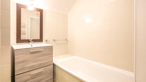 a bathroom with a bath tub and a sink and a mirror at Les Balcons d Aix N701 2P6 in Les Déserts