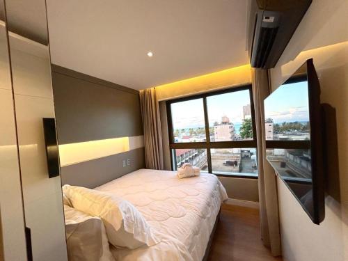 ein kleines Schlafzimmer mit einem Bett und einem großen Fenster in der Unterkunft Holanda's Prime in Tambaú