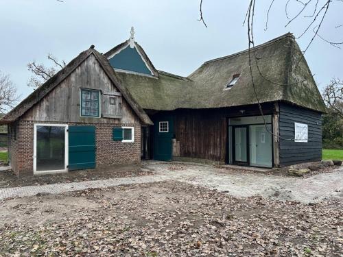 una vecchia casa in mattoni con tetto di paglia di Bed and Breakfast Reestdal a Meppel