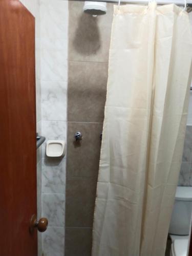 a bathroom with a shower with a white shower curtain at Centro de Tacna in Tacna