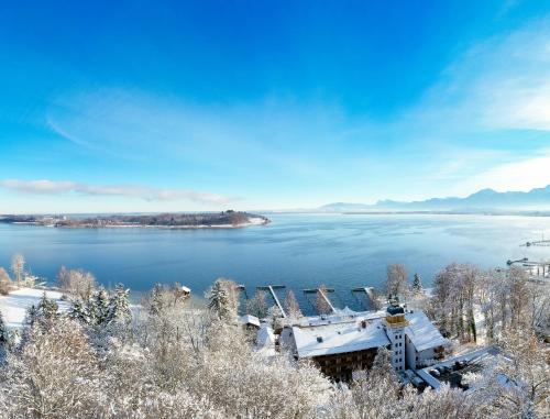 a house on the shore of a body of water at Yachthotel Chiemsee GmbH in Prien am Chiemsee